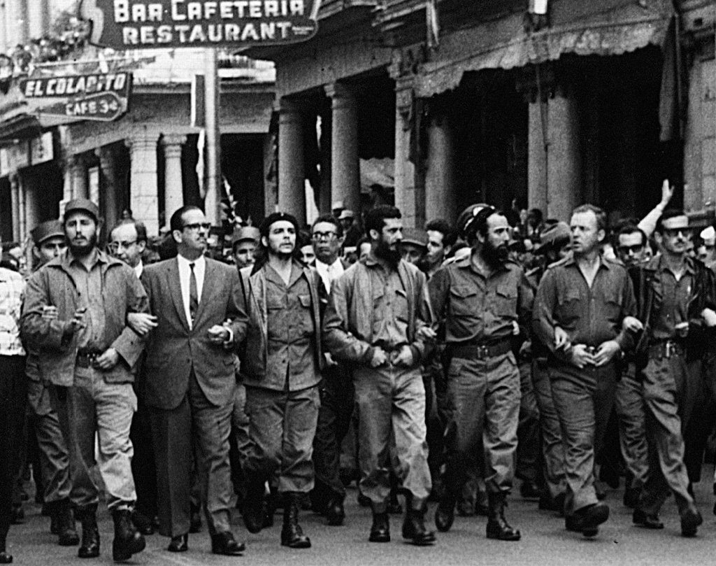 Photo was taken on March 5, 1960, in Havana, Cuba, at a memorial service march for victims of the La Coubre explosion. On the far left of the photo is Fidel Castro, while in the center is Che Guevara, on the right: William Alexander Morgan and Eloy Gutiérrez Menoyo. Photo: Unknown. Collection: Museo Che Guevara (Centro de Estudios Che Guevara en La Habana, Cuba). Public Domain.