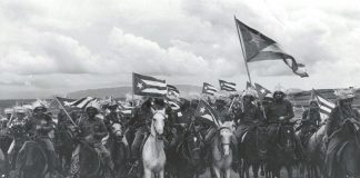 Raúl Corrales Forno famous image of the victorious 1959 Cuban Revolution entitled "La Caballería" (The Cavalry). The image shows a group of Fidel Castro's July 26 Movement rebels mounted on horses and brandishing Cuban flags whipped by the wind. January 1959. Source: Museo de la Revolución, en La Habana, Cuba. Photo: Raúl Corrales Forno. Public Domain.