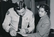 Rosa Parks being fingerprinted in February 22, 1956 by Deputy Sheriff D.H. Lackey following her arrest on December 1, 1955 for refusing to give up her seat for a white passenger on a segregated municipal bus in Montgomery, Alabama. Photo: Associated Press; restored by Adam Cuerden. Public Domain.