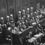 Nuremberg Trials: looking down on the defendants’ dock. Ca. 1945-46. Office of the U.S. Chief of Counsel for the Prosecution of Axis Criminality, Photographs relating to Major Nurenburg Trials, compiled 1945 – 1946, NWDNS-238-NT-592. Photo: Ray D’Addario. Public Domain.