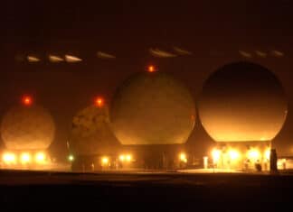 Four "golf ball" protective covers at Thule Air Base, Greenland that house satellite dishes glow during the darkness Jan. 25. Thule AB Airmen use the satellite dishes to communicate with orbiting satellites. Photo: Taken 24 January 2007 by U.S. Air Force photo/Michael Tolzmann. Public Domain.