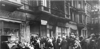 Distress of the 1920s. People stand in line in front of a shop. Photo: Unknown/German Federal Archives. (CC BY-SA 3.0 DE).