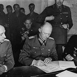 Alfred Jodl (between Major Wilhelm Oxenius to the left and admiral (Generaladmiral) Hans-Georg von Friedeburg to the right) signing the German unconditional surrender at Reims, France on 7 May 1945. Item from Collection FDR-PHOCO: Franklin D. Roosevelt Library Public Domain Photographs, 1882 – 1962 (List). Public Domain.