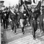 Fascist march on Rome. From left to right: Italo Balbo, Benito Mussolini, Cesare Maria de Vecchi and Michele Bianchi, 24. oktober 1922. Photo: Unknown / Illustrazione Italiana, 1922, n. 45. Public Domain.