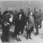 Jews captured by Waffen SS soldiers during the suppression of the Warsaw Ghetto Uprising. Photograph from a report filed by Juergen Stroop, commander of the German forces that liquidated the ghetto. Poland, April-May 1943. To the right Hasia Szylgold-Szpiro. Photo: Unknown/SS. Public domain.