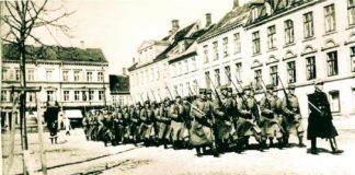 Generalstrejken i 1922. Soldater marcherer med opplantede bajonetter på Frederiksplads. (Isenkram Centret genkendes) Foto: Ukendt / Randers Stadsarkiv.