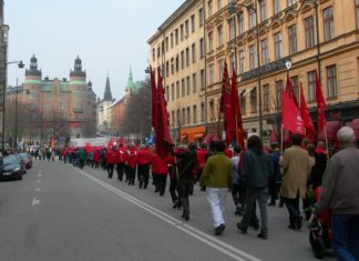 1. maj demonstration med røde faner, Stockholm, Sverige 2006. Foto: ukendt, Public Domain. - "Når jeg ser et rødt flag smælde" er skrevet af Oscar Hansen. Se nedenfor 23 juli 1895.