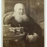 Portrættet viser den næsten 80-årige N.F.S.Grundtvig i fuld vigør, med opslåede bøger på bordet. Visitkort foto efter maleri fra 1862 af Wilhelm Marstrand (1810–1873). (CC BY-NC-ND 4.0).