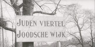 Jewish Ghetto in Amsterdam, Nederlands. WS street with large street sign: JUDEN VIERTEL JOODSCHE WIJK. 1942. See about the Dutch protests against persecutions of jews, January 25. 1941. Accessed at US Holocaust Memorial Museum, courtesy of Nederlands Instituut voor Beeld en Geluid.