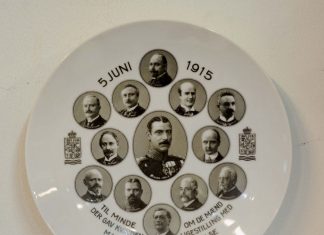 Platte fremstillet af hvidt porcelæn. Platten bærer indskriften: 5 JUNI 1915 TIL MINDE OM DE MÆND DER GAV KVINDEN LIGESTILLING MED MANDEN I LANDETS STYRELSE". Desuden bærer den portrætter af Grundlovens Ministerium 5. juni 1915. I alt 13 portrætter af: Kong Christian 10., Zahle, Keiser Nielsen, Ove Rode, Munch, Hassing Jørgensen, Edv. Brandes, Scavenius, Kr. Pedersen, Borgbjerg, Kl. Berntsen, Slengerik, Hammerich. Platten er signeret „Hans Friis“. Se om den nye mere demkratiske grundlov, 5.juni 1915.