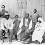 Harriet Tubman (c. 1820 – March 10, 1913), far left, with family and neighbors, circa 1887, at her home in Auburn, NY. Left to right: Harriet Tubman; Gertie Davis {Watson} (adopted daughter born 1874, died ?) behind Tubman; Nelson Davis (husband and 8th USCT veteran); Lee Chaney (neighbor’s child); “Pop” John Alexander (elderly boarder in Tubman’s home); Walter Green (neighbor’s child); Blind “Aunty” Sarah Parker (elderly boarder); Dora Stewart (great-niece and granddaughter of Tubman’s brother Robert Ross aka John Stewart). [Note: Dora Stewart is sometimes cropped out of other versions of this photograph]. Date: Catherine Clinton (2004) gives the date as c. 1885. Source: Bettman/Corbis, through The New York Times photo archive, via their online store, here. Photographer William H. Cheney, South Orange, NJ. Public Domain.