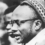 Portrait of Amilcar Cabral, wearing the sumbia – traditional skullcap [presumably during the Cassacá Congress, freed from the southern region of Guinea]. Februar 1964. Source: 	http://casacomum.org/cc/visualizador?pasta=05221.000.030 Photo: Anonymous. Public Domain.