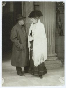 Johan Skjoldborg og Emma Gad konverserer i kolonnaden ved Amalienborg i forbindelse med Nordisk Forfatterstævne, 1919. Foto: Ukendt/Det Kongelige Biblioteks Billedsamling. (CC BY-NC-ND 4.0).
