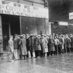 Unemployed men queued outside a depression soup kitchen opened in Chicago by Al Capone. The storefront sign reads “Free Soup Coffee & Doughnuts for the Unemployed.” February 1931. Photo: Unknown author or not provided. Current location: National Archives at College Park, National Archives and Records Administration. Public Domain.