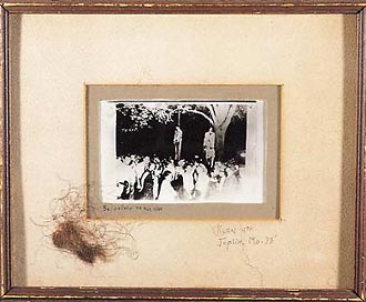 The lynching of Thomas Shipp and Abram Smith, a large gathering of lynchers. August 7, 1930, Marion, Indiana. Photo: Photo: Lawrence Beitler (1885–1960) Photographer) ©. Gelatin silver print. Copy photo. Frame, 11 x 9", photo, 3 7/8 x 2 3/4" inscribed in pencil on the inner, gray matte: "Bo pointn to his niga." On the yellowed outer matte: "klan 4th Joplin, Mo. 33." Flattened between the glass and double mattes are locks of the victim's hair." From: Without Sanctuary : Photographs and Postcards of Lynching in America. (Website, Picture # 28)