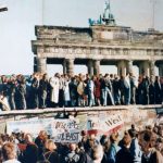 The Fall of the Berlin Wall, 1989. The photo shows a part of a public photo documentation wall at the Brandenburg Gate, Berlin. The photo documentation is permanently placed in the public. Photo: Original photo taken 9 November 1989 by unknown author. Reproduction from public documentation/memorial by Lear 21 at English Wikipedia. (CC BY-SA 3.0).