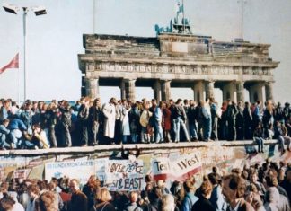 The Fall of the Berlin Wall, 1989. The photo shows a part of a public photo documentation wall at the Brandenburg Gate, Berlin. The photo documentation is permanently placed in the public. Photo: Original photo taken 9 November 1989 by unknown author. Reproduction from public documentation/memorial by Lear 21 at English Wikipedia. (CC BY-SA 3.0).