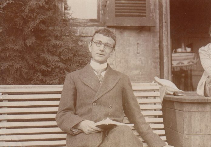 Forfatteren Otto Gelsted (1888-1968) sidder og læser på en hvid tremmebænk et ukendt sted. Taget i 1915, mens Otto Gelsted var huslærer for maleren Johannes Larsens to sønner på