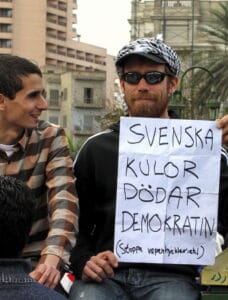 A Swede who joined the 2011 Egyptian protests in Tahrir Square. The text reads: "Swedish bullets kill democracy (stop arms hypocrisy!)", in reference to the use by Egyptian riot police and security forces of ammunition made in Sweden. Photo: Taken 6 February 2011 by Sherif9282. (CC BY-SA 3.0).