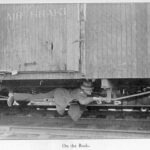 Jack London lies on the rods underside of a boxcar, 1907. Public Domain.