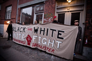 Banner fra demonstrationen 2012 foran Søllerødgade 33: 'Black and white. Unite and fight' . (Foto: Mette Kramer Kristensen).