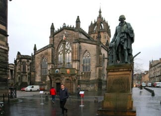 Adam Smith statue in Edinburgh's High Street with St. Giles High Kirk behind. Photo taken 23 November 2018 by Andraszy. (CC BY-SA 4.0).