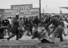 Bloody Sunday. In this March 7, 1965, file photo, a state trooper swings a billy club at John Lewis, right foreground, chairman of the Student Nonviolent Coordinating Committee, to break up a civil rights voting march in Selma, Ala. Lewis sustained a fractured skull. Lewis, who carried the struggle against racial discrimination from Southern battlegrounds of the 1960s to the halls of Congress, died Friday, July 17, 2020. (AP Photo/File). Photo: bswise. (CC BY 2.0).