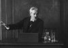 Screenshot fra den danske stumfilm "Professor Georg Brandes paa Universitetets Katheder" med Georg Brandes, der taler på Københavns Universitet i 1912. Fotograf: Ukendt. Public Domain.