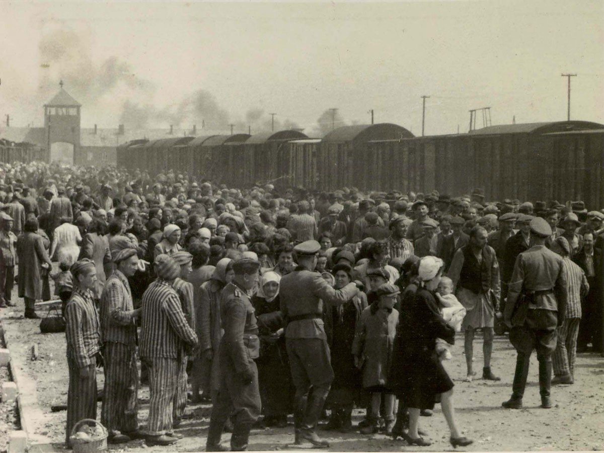 "Selection" of Hungarian Jews on the ramp at the death camp Auschwitz-II (Birkenau) in Poland during German occupation, May/June 1944. Jews were sent either to work or to the gas chamber. The photograph is part of the collection known as the Auschwitz Album. May or June 1944, Auschwitz-Birkenau, Poland. Source: Yad Vashem. The album was donated to Yad Vashem by Lili Jacob, a survivor, who found it in the Mittelbau-Dora concentration camp in 1945. Author Unknown. Public Domain